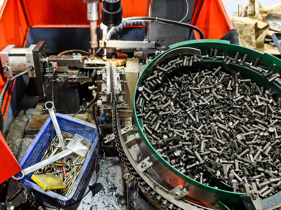 Vibratory bowl feeder and tooling station feeding tubular fasteners on a production cell